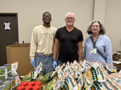 MCC alumnus Mike Rague, center, works alongside volunteers to distribute food at We Care Wednesdays.