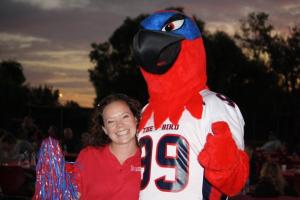 Woman holding a pom-pom next to the Thor mascot