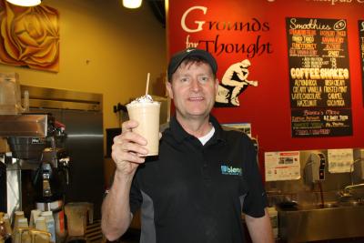 Stephen Morgan holding a beverage in the coffee shop.