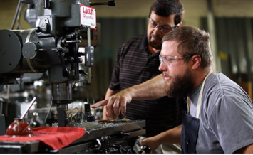 two people working with a large machine