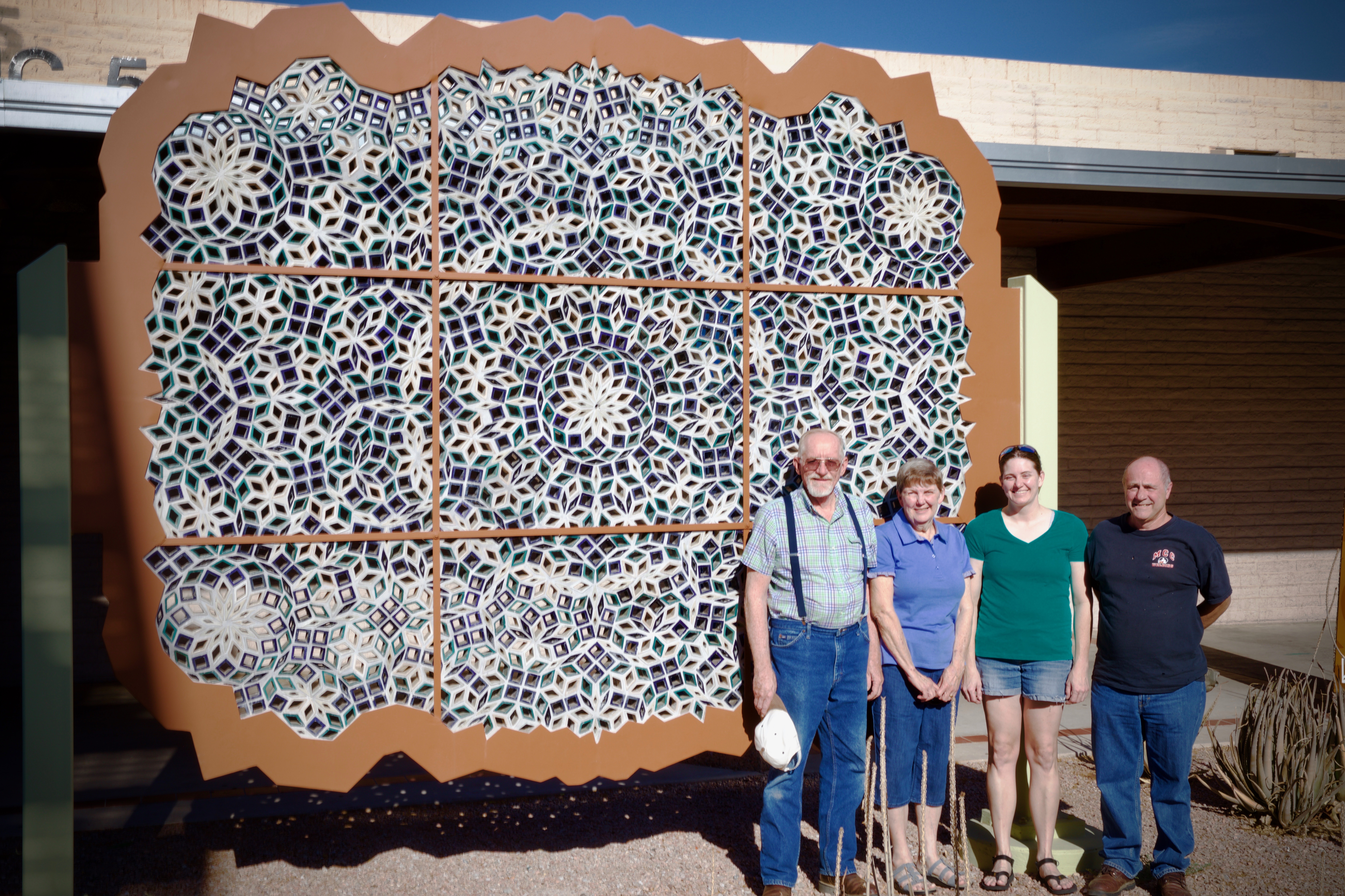 Merri Stafford pictured with her parents Kathy and Larry Stafford and an MCC Instructor in front of a sculpture.