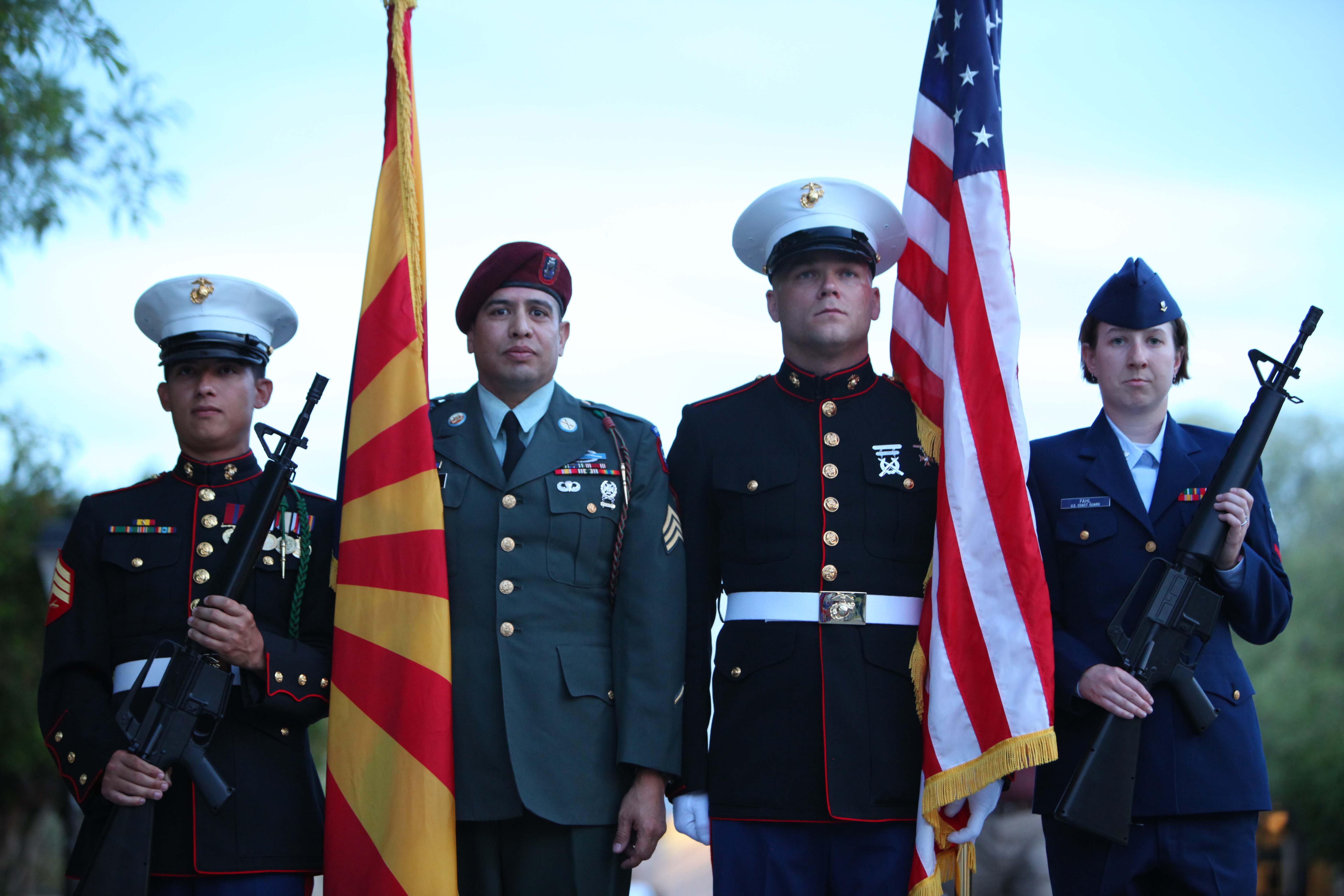 Military service members in uniform holding flags