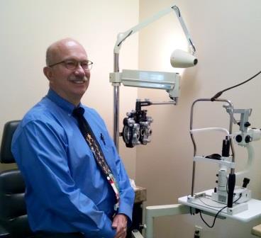  Dr. James Abbott posing next to optometry equipment