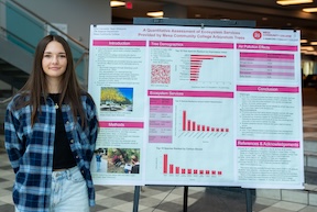 Elliot Carosella with a poster presenting her research: A Quantitative Assessment of Ecosystem Services Provided by Mesa Community College Arboretum Trees.