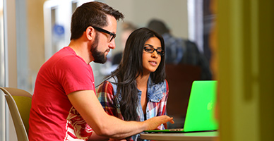 Two students working at a laptop