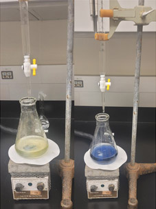 Two beakers partially filled with liquid in a lab setting