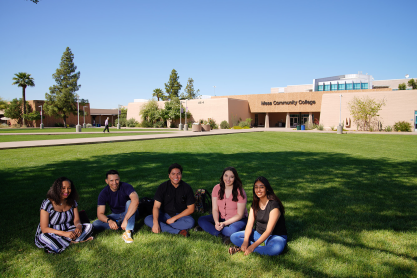 Five students sitting on the campus lawn.