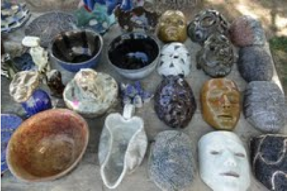 A pottery display including bowls and face masks.