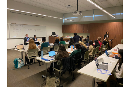 Group of high school students sitting in classrooms with laptops.