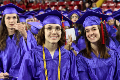 Two graduates in blue regalia during the 2024 MCC commencement ceremony. 