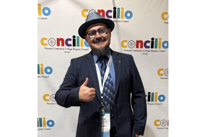 Cesar Beccera smiling showing a thumbs up in front of a Concillio branded backdrop. 