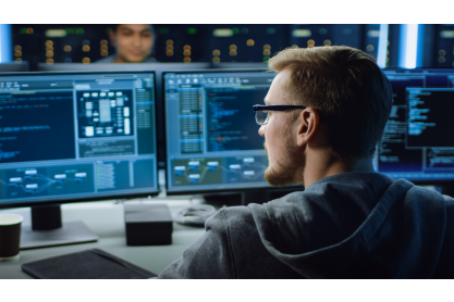 Person working on computer programing using dual monitors.