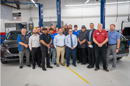 MCC students and faculty with representatives from Mazda North American Operations and local dealerships posed between two Mazda vehicles donated to MCC for the MAST program.. 