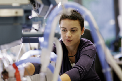 Person repairing a large piece of medical equipment
