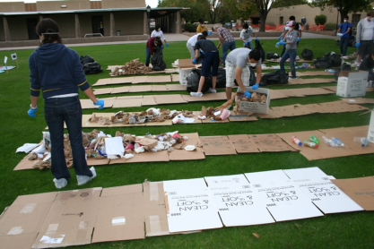Sorting through trash on rows of flat cardboard.