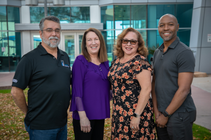 Four honorees posing for a photo outside of the library. 