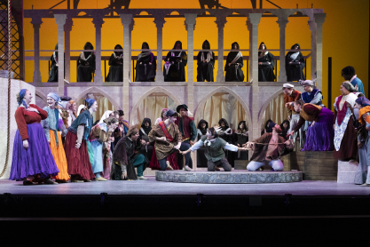Group of people in colorful medieval costumes on stage
