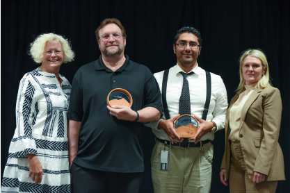 Two faculty holding awards next to two administrators.