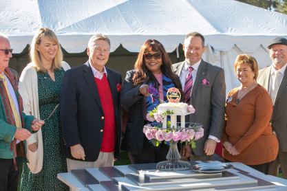 MCC president Dr. Tammy Robinson cuts a small ceremonial cake adorned with rose blossoms.