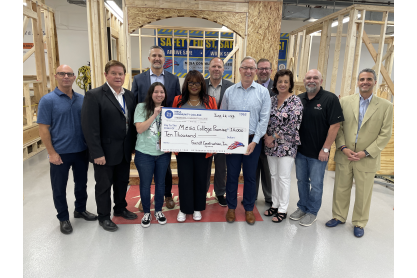 Representatives from Sundt Construction MCC and City of Mesa Mayor Giles standing around an oversized check for $10,000. 