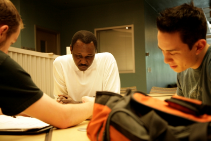 Two students study looking down at a table.