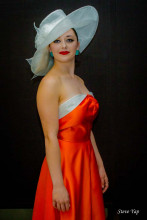 Long red dress with straight across neckline and white hat