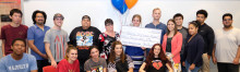 Michelle Mazzucco receives large check, pictured with her class. 