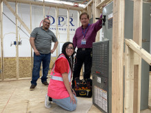 MCC students Agustin and Lilly Hernandez with Construction Trades faculty Dr. David Cain inside a framed structure.