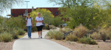 Two students walking on a campus sidewalk