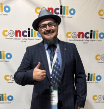 Cesar Beccera smiling showing a thumbs up in front of a Concillio branded backdrop. 