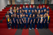 Group of RN graduates, class of 2025, in dark blue scrubs. 