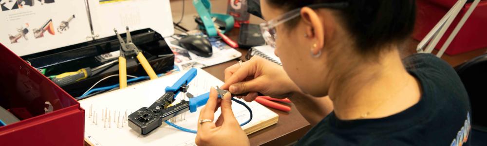 A student trimming wire in a classroom.