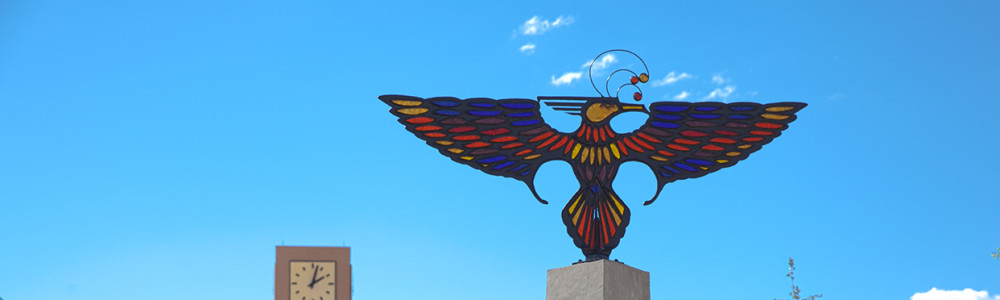 The stained glass thunderbird with MCC clocktower in the background.
