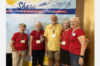 Members if New Frontiers standing in front of a banner, 4 women and 1 man.
