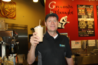 Stephen Morgan holding a beverage in the coffee shop.