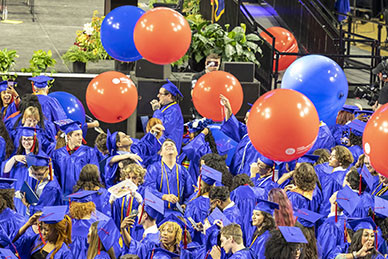 Graduates celebrating as balloons drop.