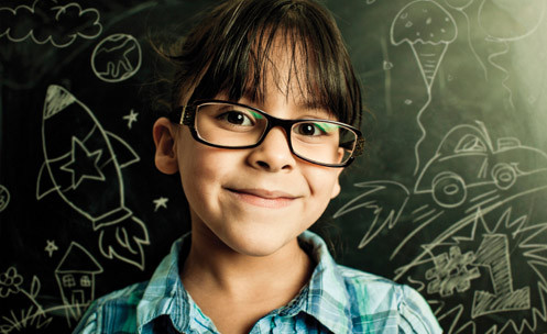 young female student wearing glasses in front of a blackboard