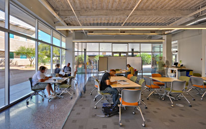 students sitting at tables in a college classroom reading and doing independent work