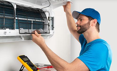 A person repairing an indoor air conditioner.