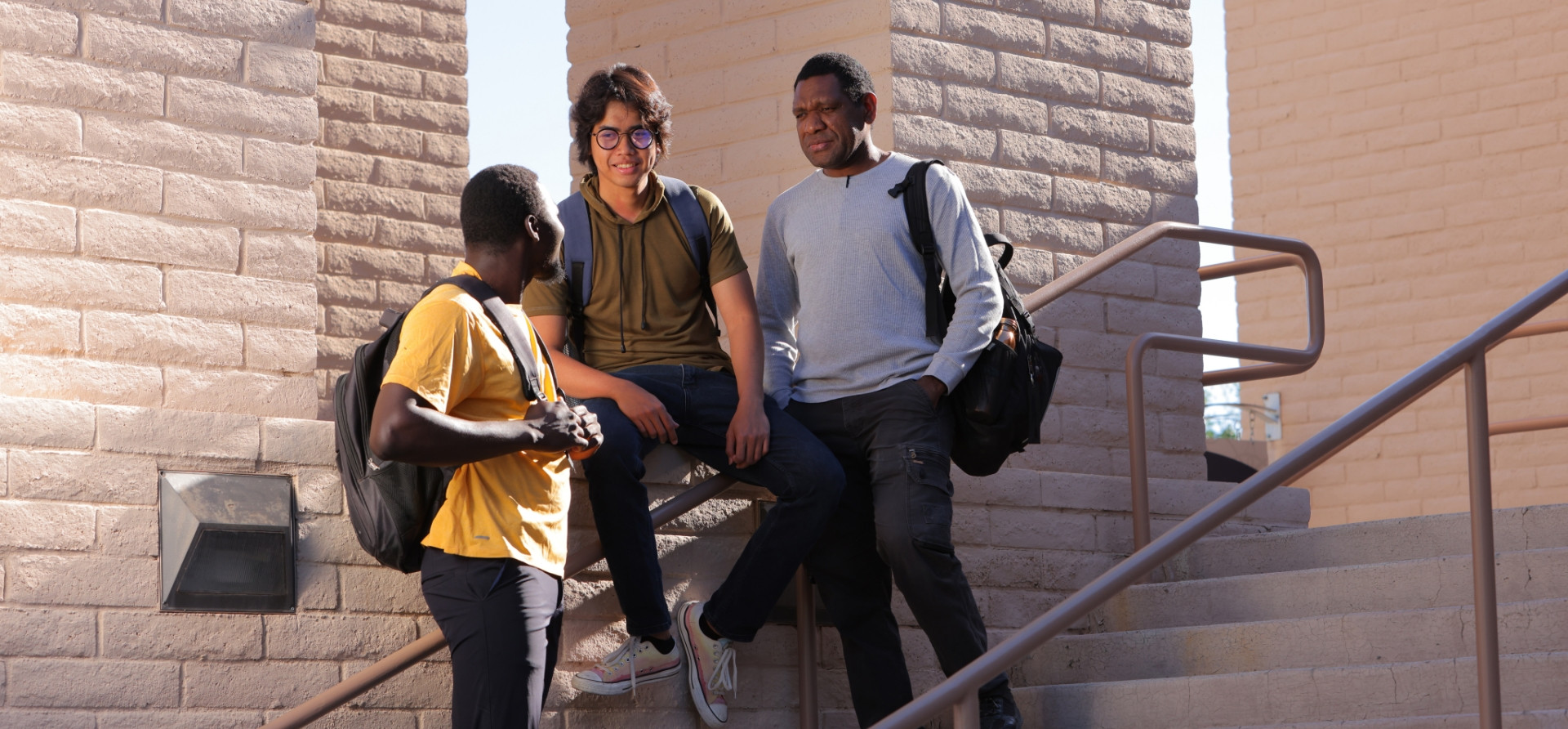 Three students talking near the clock tower