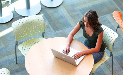 A student on a laptop from overhead.