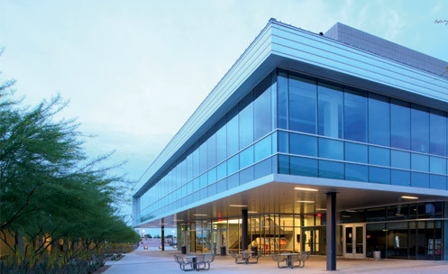 The exterior of a building with a large patio on the first floor.