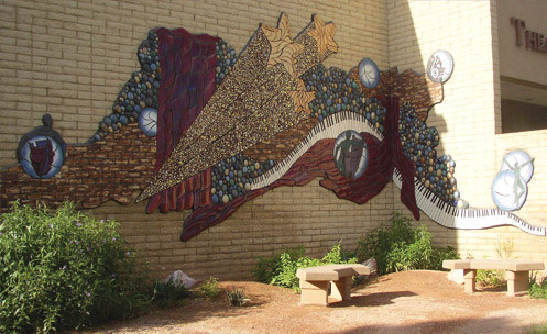 An outdoor mural featuring stars, volleyballs and a keyboard.