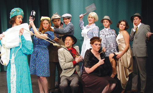 The cast of a play in costume with early 20th century clothing.