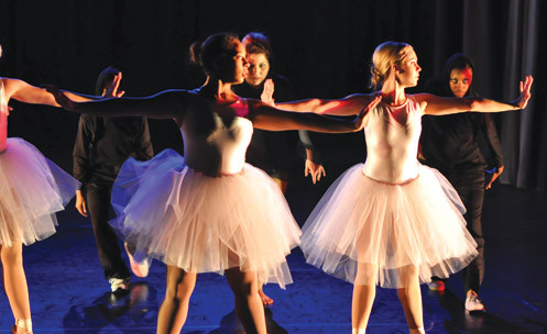 Ballerinas lined up with other dancers behind.