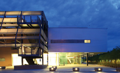 A building exterior lit up at night with an outside staircase.