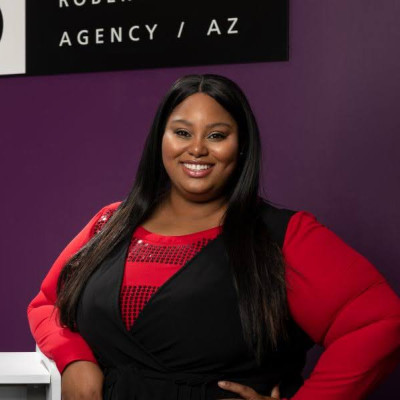 Woman smiling in front of modeling agency sign