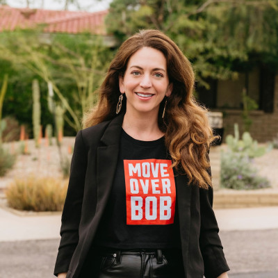 Kate Glantz posing in a black jacket over a shirt with the words Move Over Bob. 