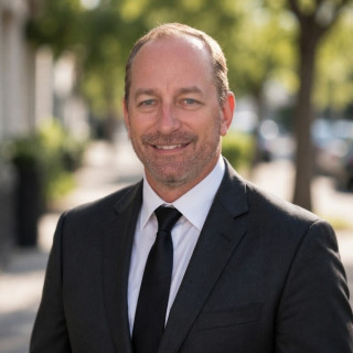Michael Trevillion in a black jacket, white shirt and tie