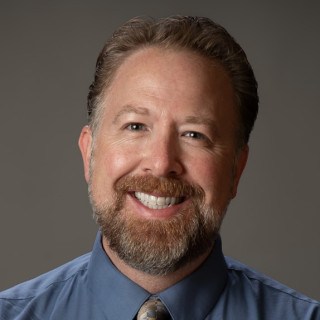 Michael Voss wearing a blue button up shirt with a tie